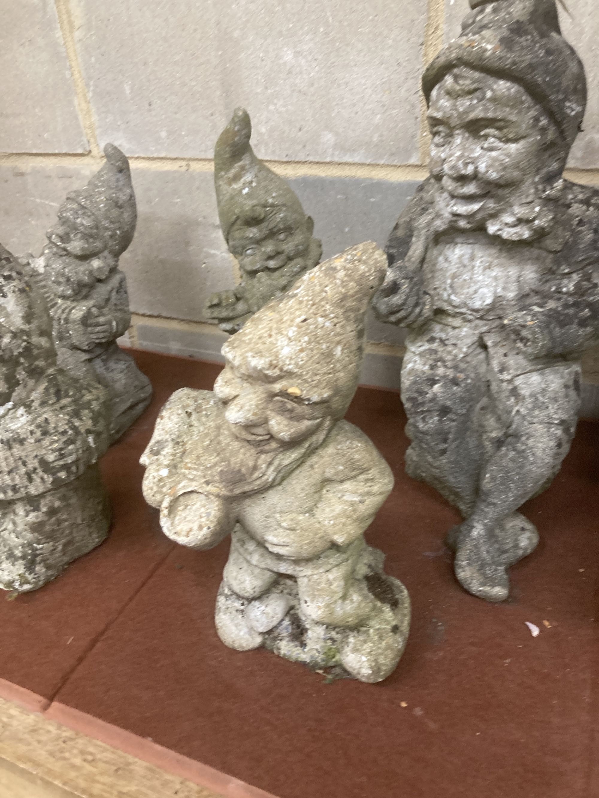 Six reconstituted stone gnome garden ornaments, largest 60cm high